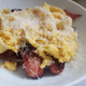 White bowl full of sliced meat, scrambled eggs, pasta, and cheese